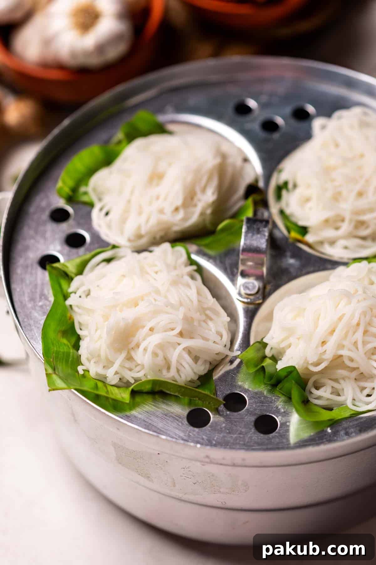 Feathery Steamed Rice Nests 3 Rice Idiyappam steaming delicately on banana leaves in an idli steamer