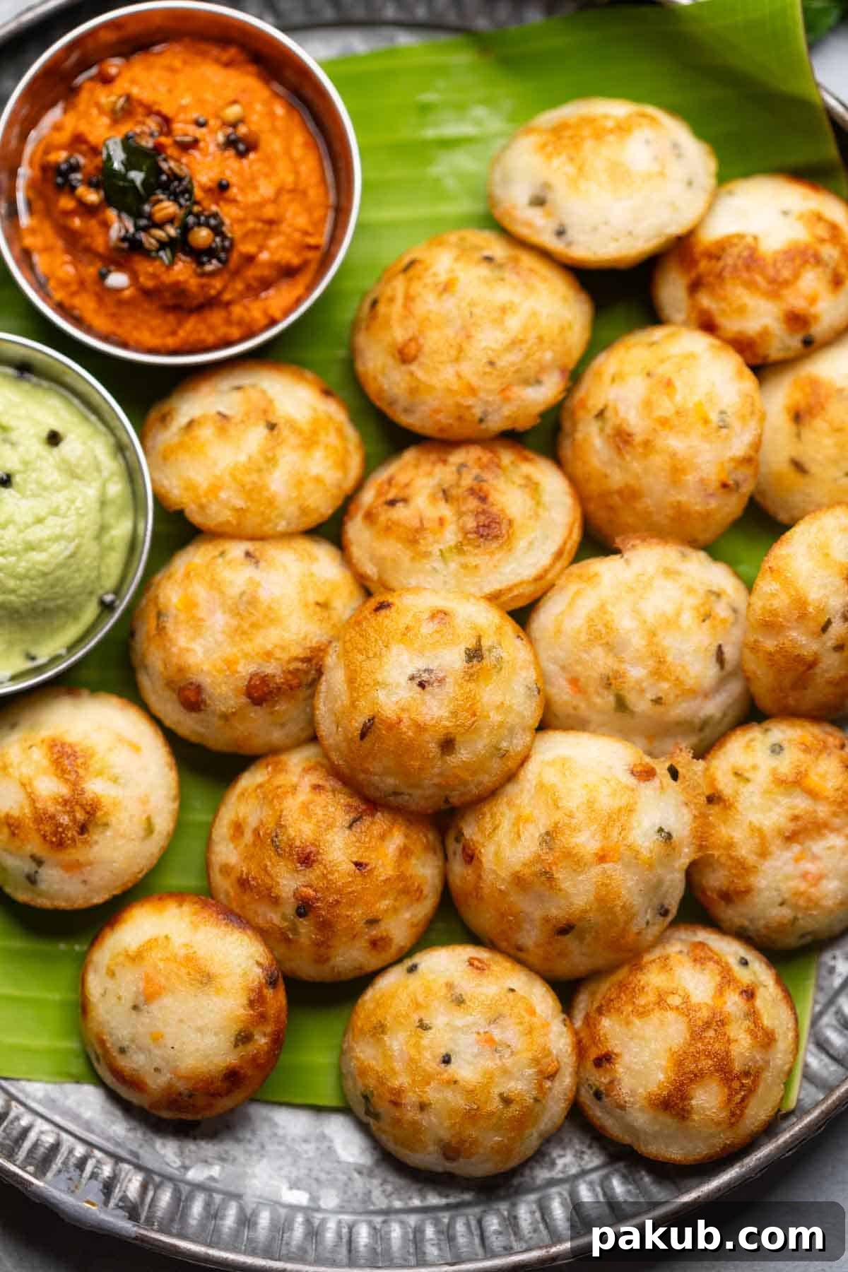 Flavorful Paniyaram Fritters Recipe 2 Freshly cooked paniyaram served on a banana leaf platter with accompaniments