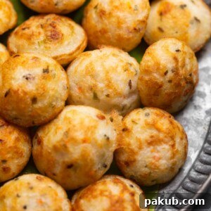 Freshly cooked paniyaram served on a banana leaf platter with accompaniments