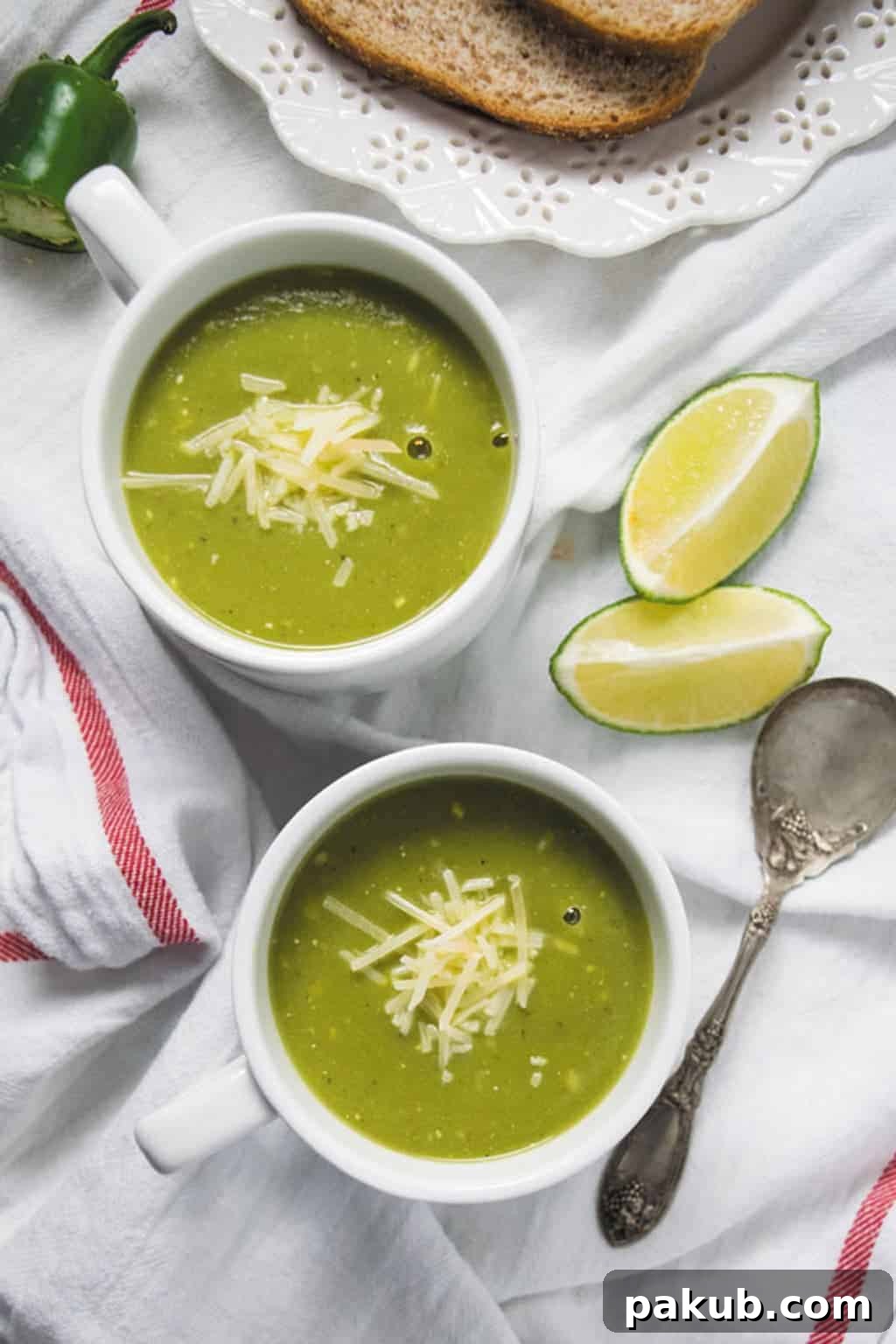 Pressure Cooker Zucchini Basil Soup Two white cups filled with steaming pressure cooker zucchini basil soup, garnished with fresh basil leaves and a swirl of cream, ready to be served.