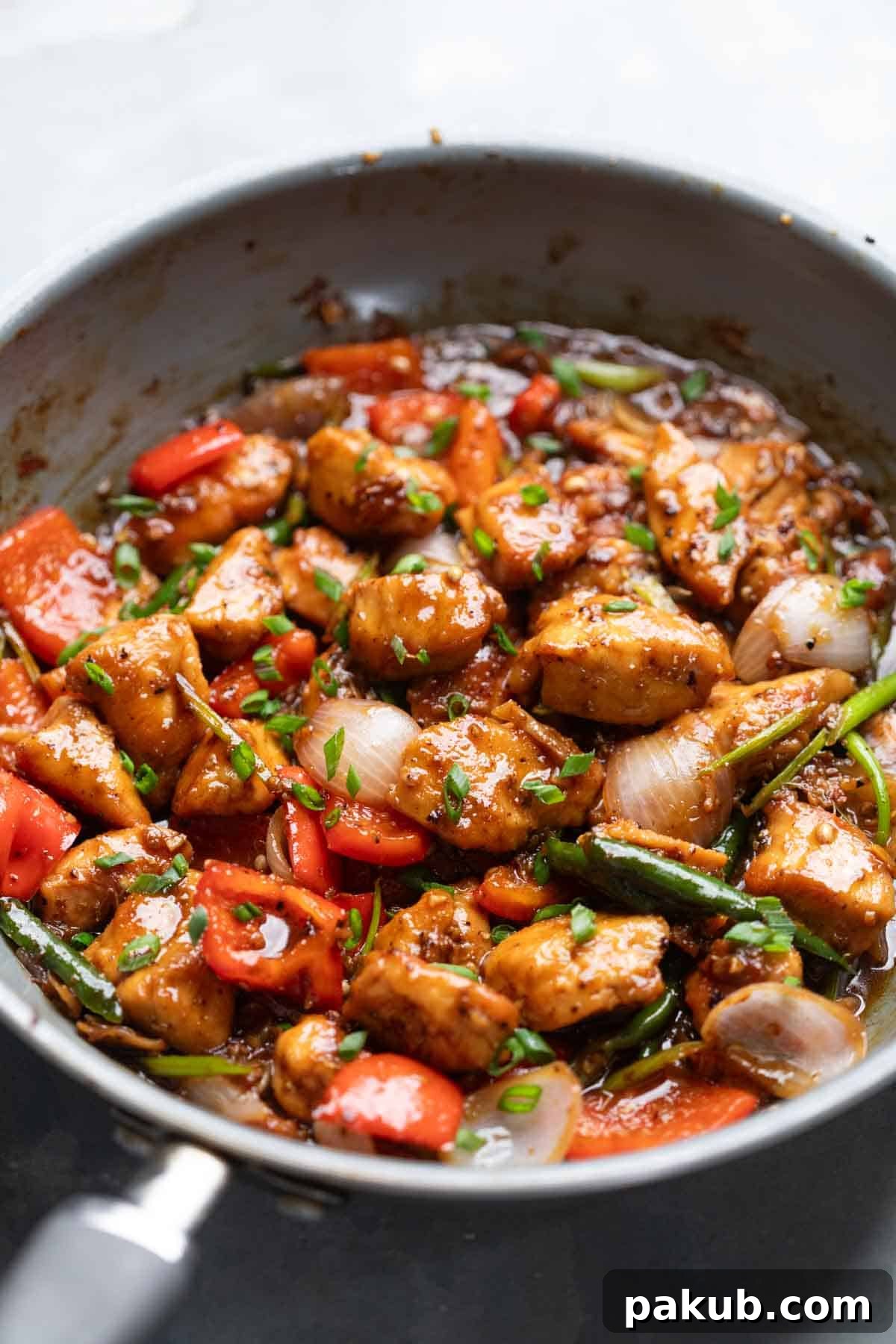 Bold Black Pepper Chicken 2 Close up of Black Pepper Chicken being cooked in a pan, showcasing crispy chicken and vibrant vegetables.