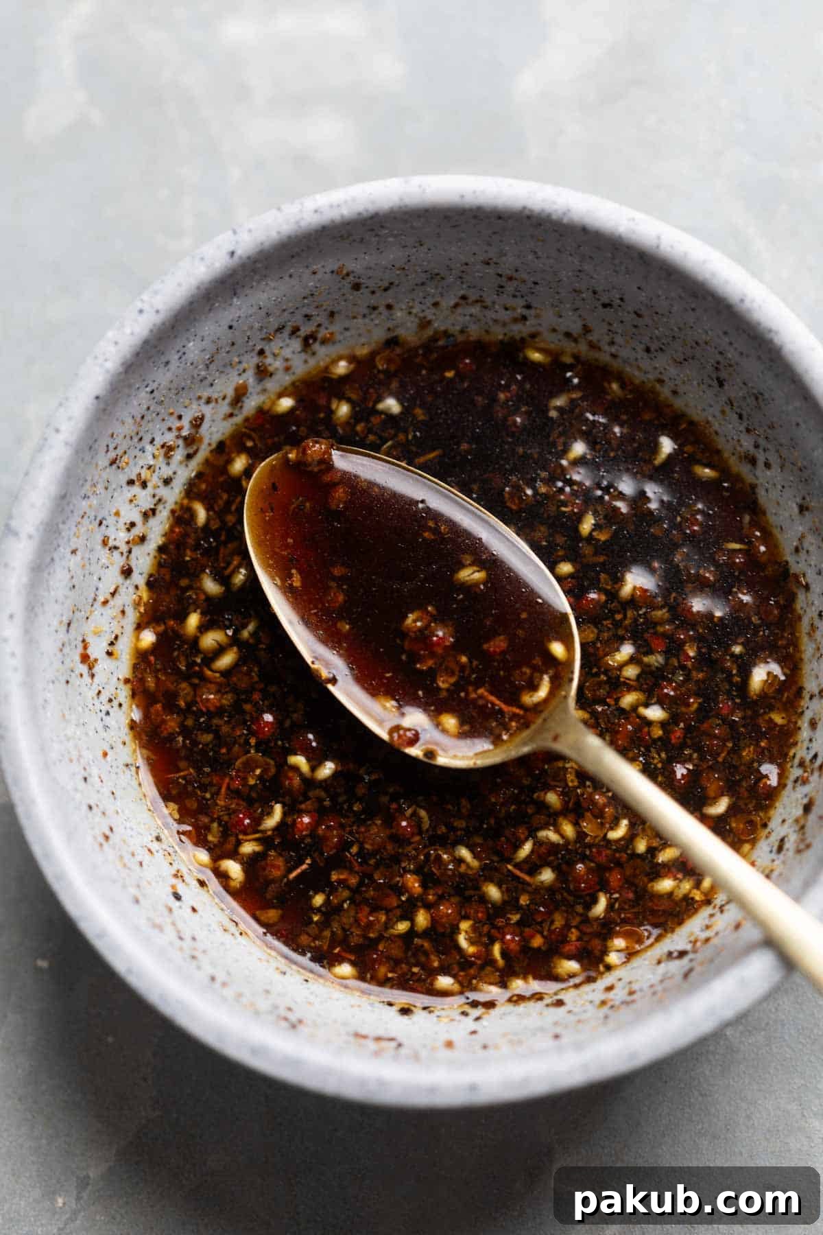 Bold Black Pepper Chicken 3 Close up of black pepper sauce in a bowl with a spoon, ready to be added to the chicken.