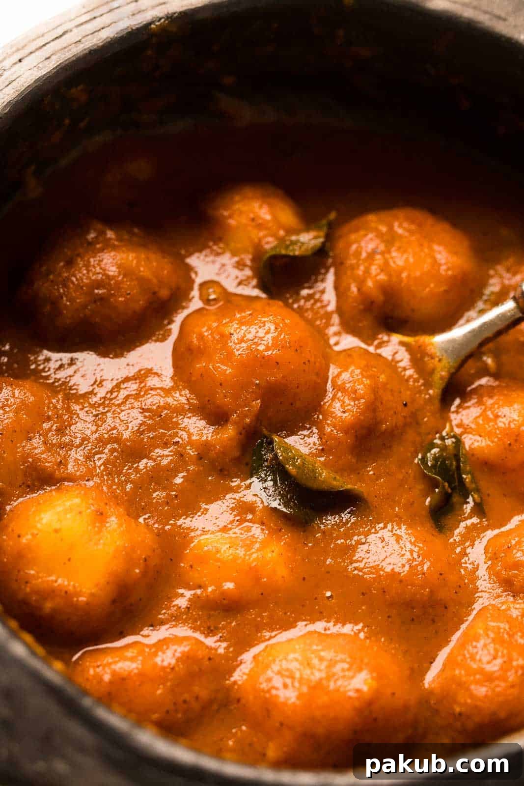 Sun-Kissed Mangalorean Mango Curry 3 Rich and fragrant Mangalorean Ripe Mango Curry served in a rustic clay pot, ready to be enjoyed.