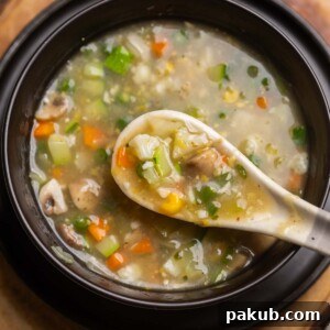 Eight treasure soup served in a black soup bowl with a white soup spoon ready to be eaten