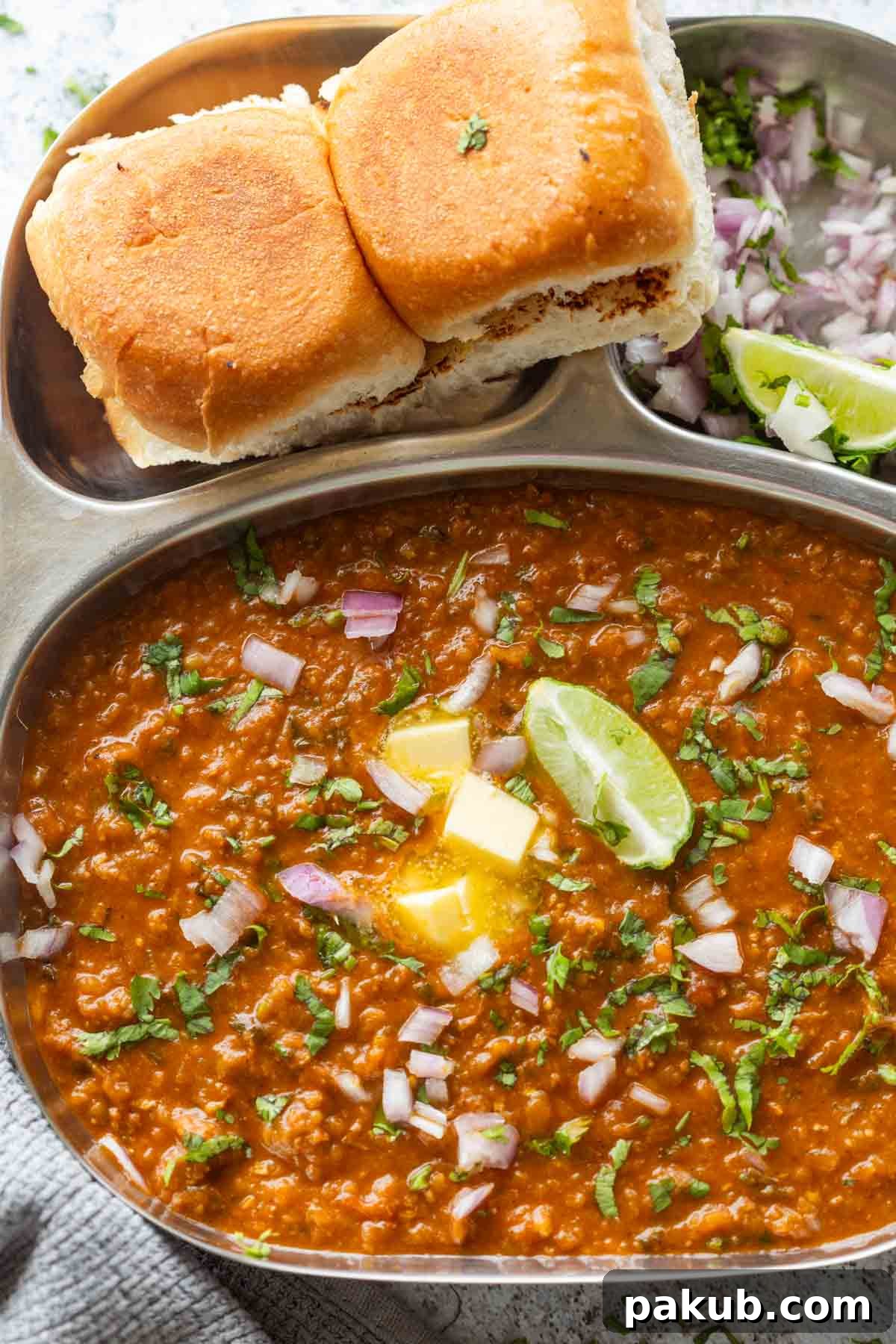 Beautifully garnished pressure cooker pav bhaji served on a rustic plate, ready to be enjoyed.