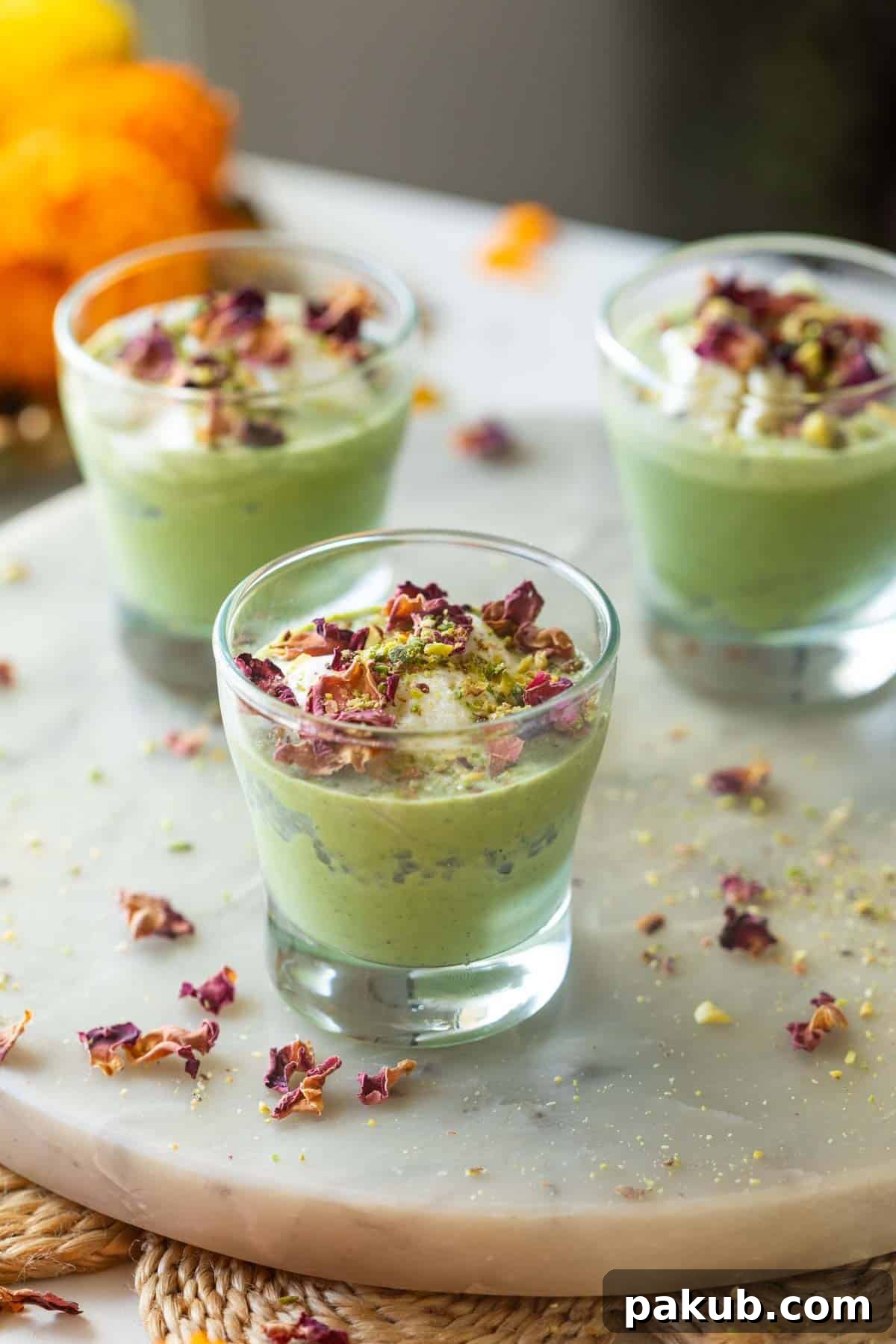 Colourful Falooda Paan Shots served elegantly on a white platter, garnished with vibrant rose petals and crushed pistachios