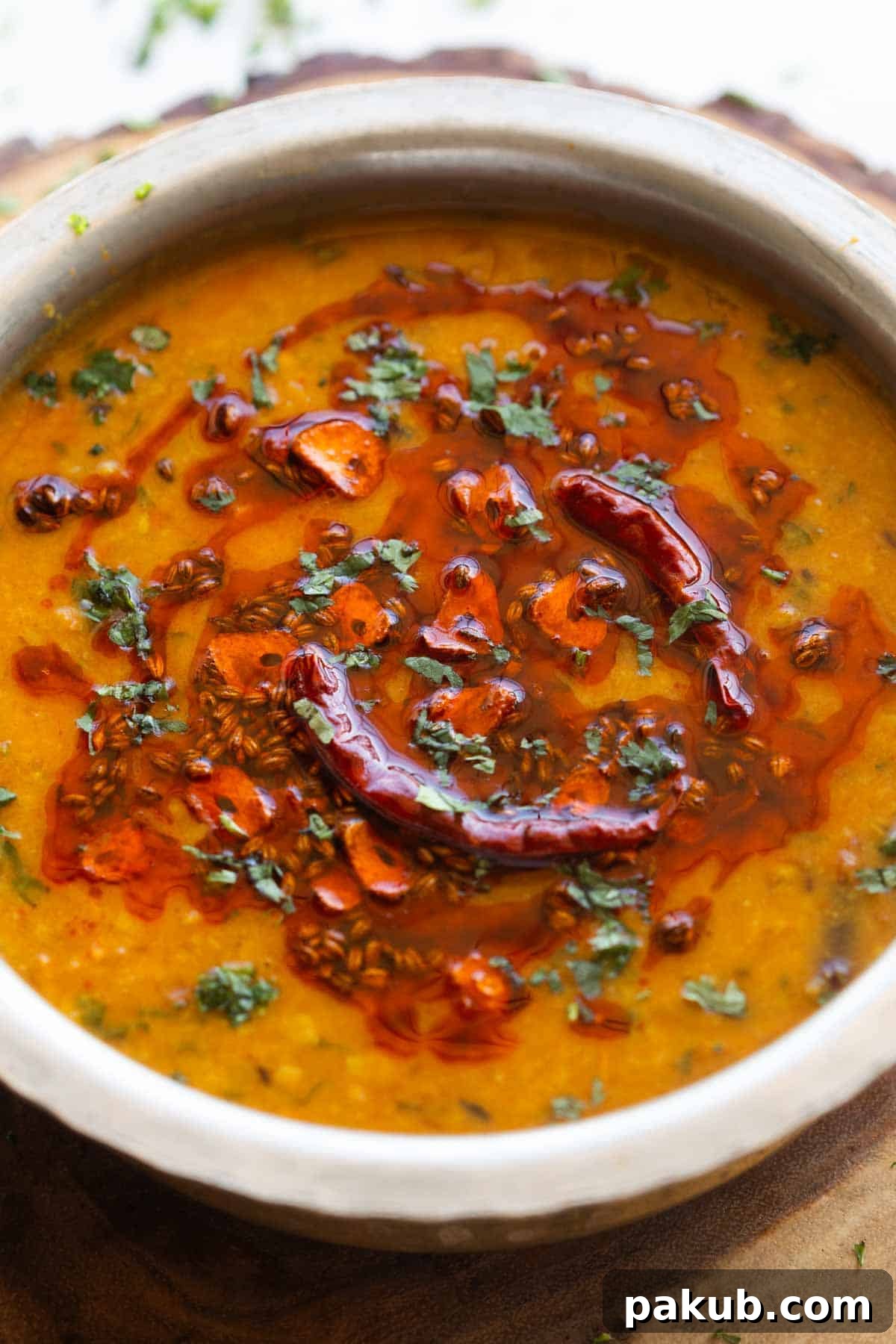Spiced Golden Lentils 3 A close-up image of creamy Dal Tadka, showing its rich texture and the vibrant, sizzling tempering on top, garnished with fresh herbs.