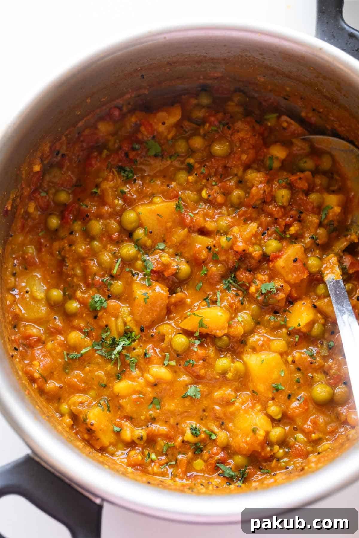 Freshly made aloo matar in the pressure cooker, showcasing vibrant colors and inviting texture
