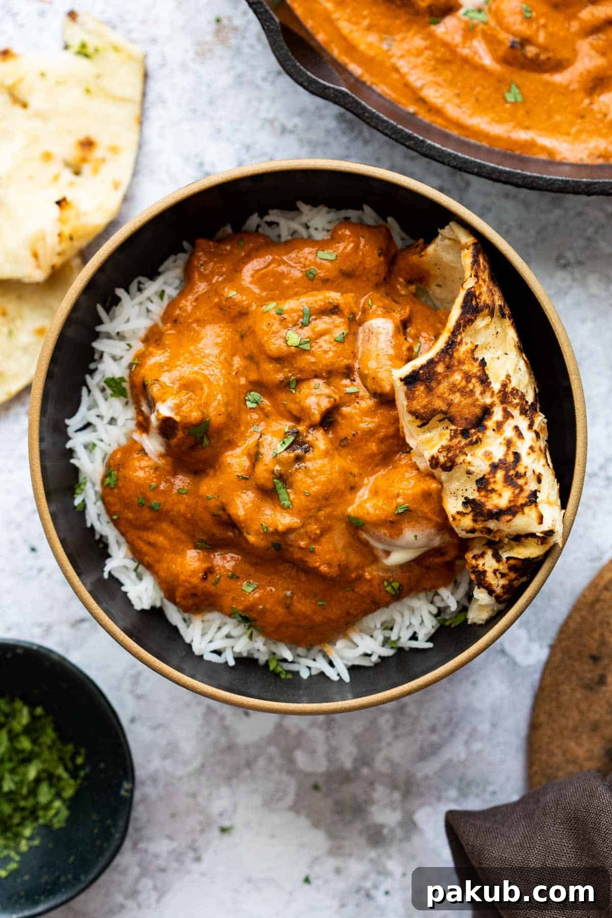 The Ultimate Creamy Butter Chicken 2 Butter Chicken served in a bowl with rice and naan bread