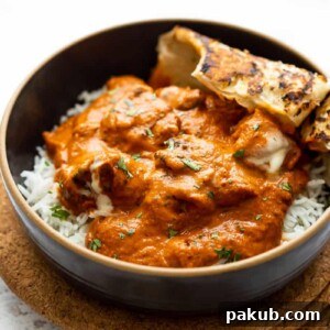 Butter Chicken served in a bowl with rice and naan bread