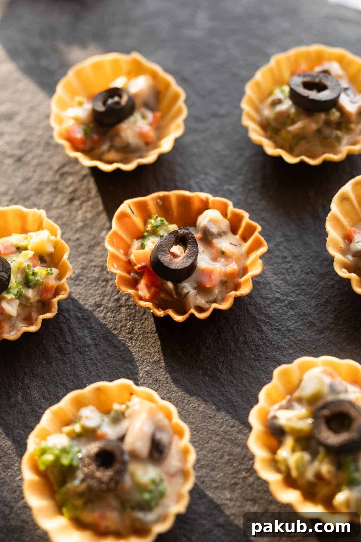 Plant-Powered Appetizers 3 Close-up view of a selection of veg canapés on a black serving board, showcasing their vibrant colors and appealing texture.