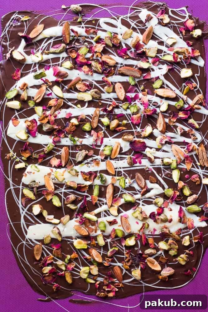 Easy 5-Ingredient White and Dark Chocolate Rose Pistachio Bark Visually stunning White and Dark Chocolate Rose Pistachio Bark, showcasing the intricate swirl of chocolates adorned with vibrant green pistachios and delicate rose petals. Perfect for homemade gifting and quick dessert cravings.