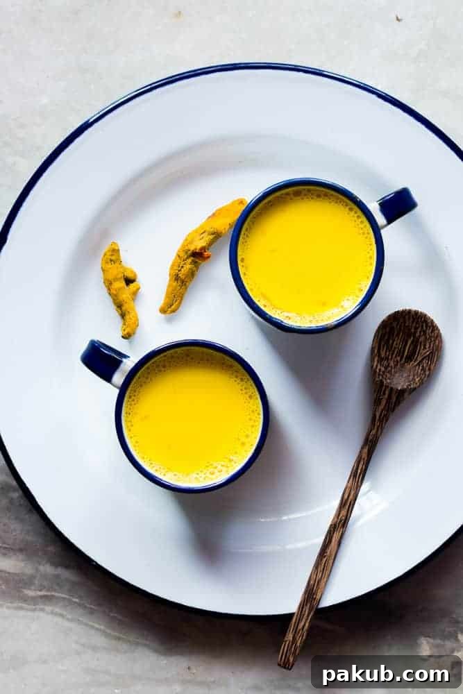 Craft the Perfect Golden Turmeric Milk 2 A warm cup of Golden Turmeric Milk, garnished with a sprinkle of turmeric powder and a cinnamon stick, sits on a rustic wooden surface, embodying comfort and health.