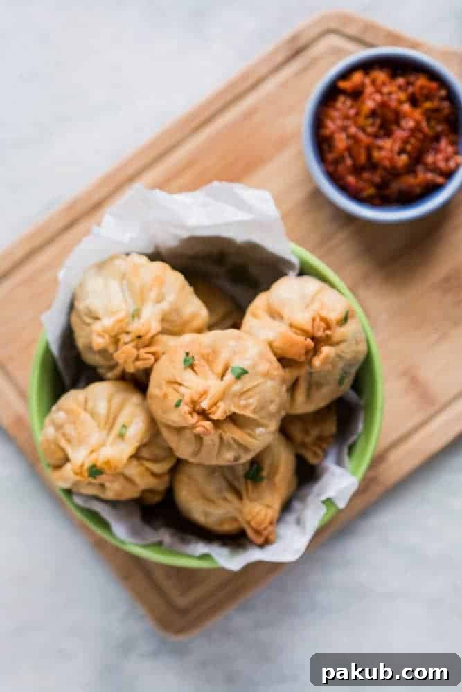 Golden Vegetarian Chinese Potli Samosa Wontons A plate of freshly fried Vegetarian Chinese Potli Samosa Wontons, golden brown and ready to serve.