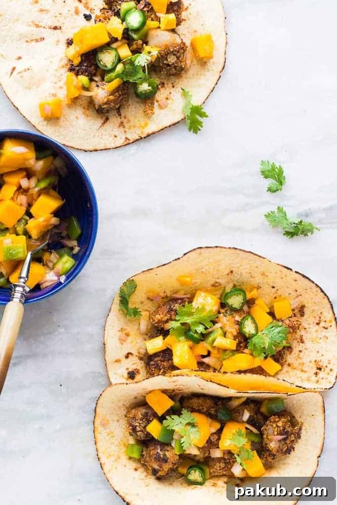 Delicious Healthy Oats Crusted Fish Tacos with vibrant Mango Salsa, ready to eat and garnished with fresh cilantro.