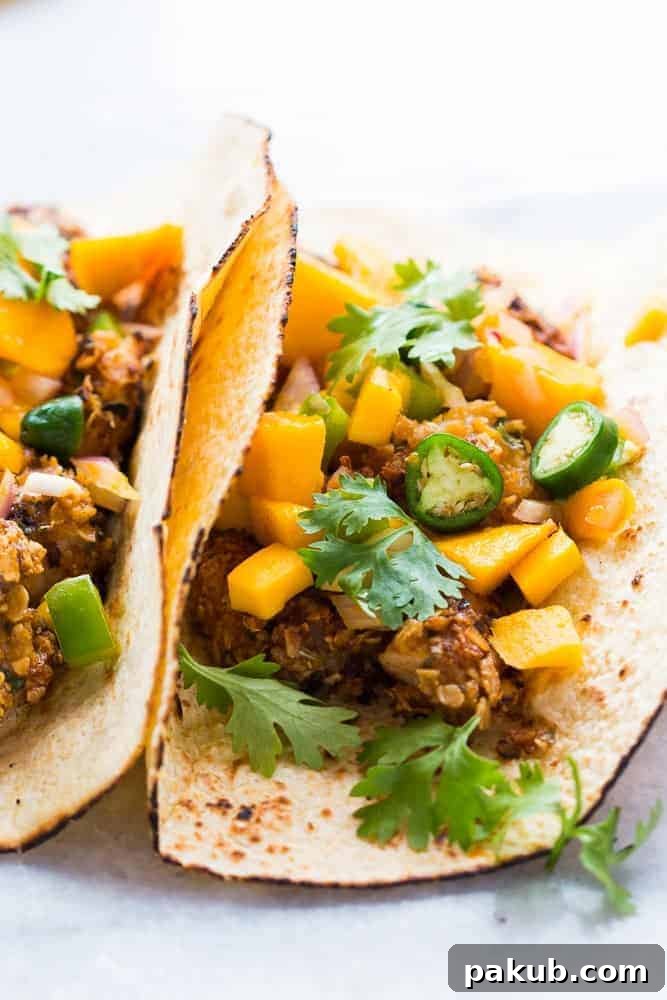 A trio of healthy oats crusted fish tacos arranged neatly on a rustic wooden board, showcasing their vibrant toppings and inviting presentation.