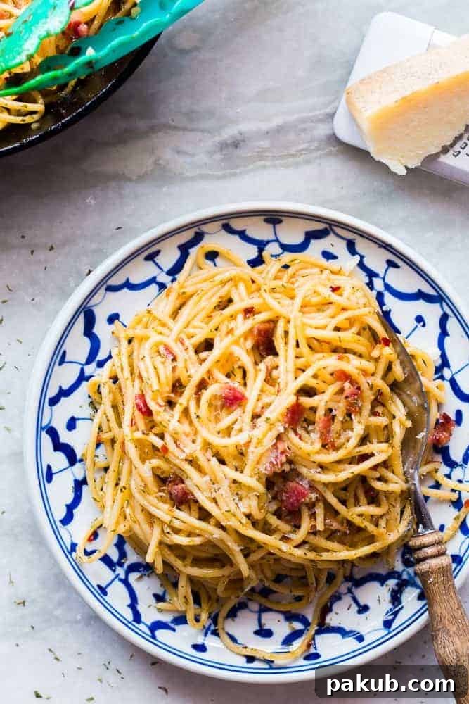 Served Bacon Spaghetti Aglio Olio Bacon Spaghetti Aglio Olio served in elegant white and blue patterned plates.