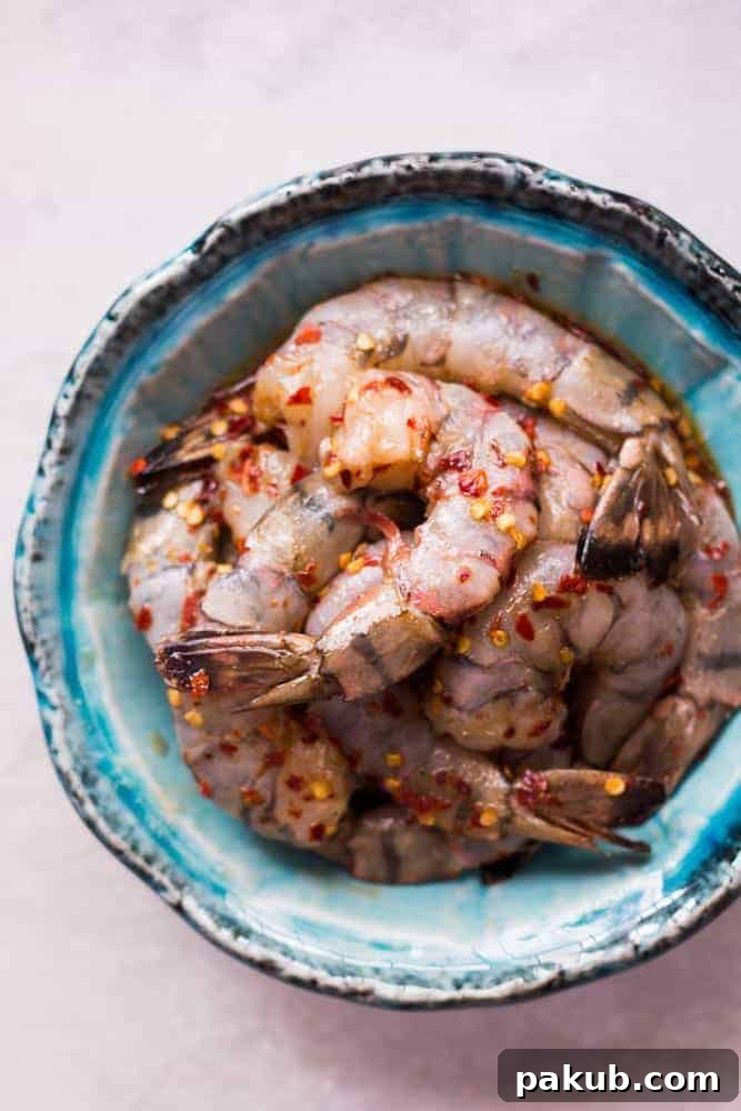 Quick & Easy Honey Chilli Garlic Tiger Prawns with Vegetables Close-up of Honey Chilli Garlic Tiger Prawns cooking in a pan with snow peas, highlighting the rich texture and vibrant colors of the stir-fry.