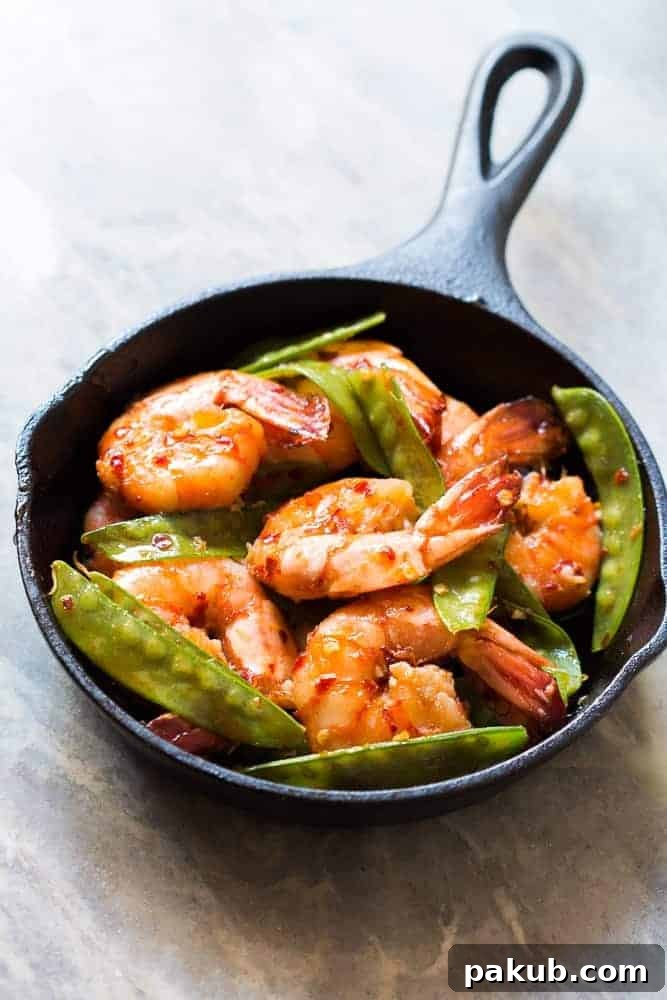 Serving Honey Chilli Garlic Tiger Prawns with Rice A serving of 5-ingredient Honey Chilli Garlic Tiger Prawns plated with a side of steamed rice, ready to be enjoyed as a fast and healthy meal.