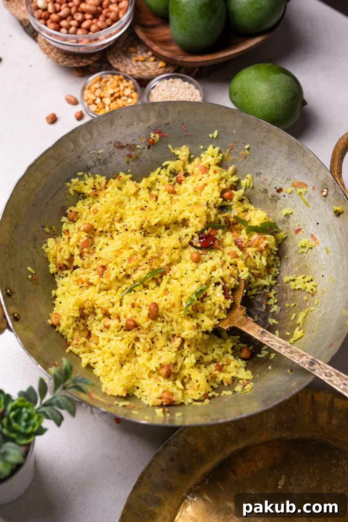 Raw Mango Rice: A Tangy South Indian Summer Treat Freshly cooked raw mango rice in a traditional Indian kadai with a ladle, garnished with fresh curry leaves and a sliced raw mango nearby. The rice has a bright, inviting yellow hue.