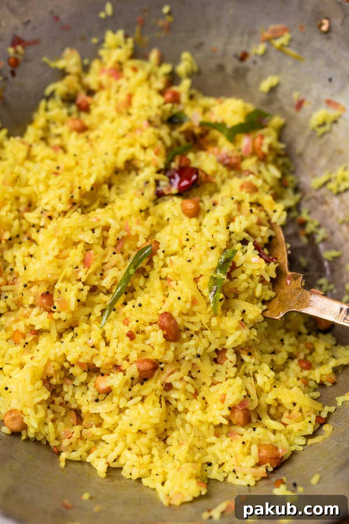 Delicious & Versatile Raw Mango Rice in a Serving Bowl A close-up of a serving bowl filled with vibrant raw mango rice, garnished with fresh curry leaves and coriander, with a wooden ladle nestled beside it, showcasing its delicious texture.