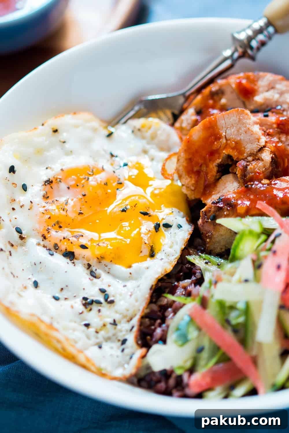 Close-up view of the appetizing Schezwan Chicken Bowl, highlighting the textures and vibrant colors of the ingredients.