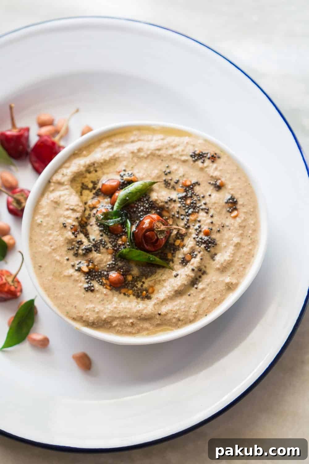 A bowl of creamy peanut chutney accompanied by a stack of crispy dosas, ready for a delightful South Indian breakfast.