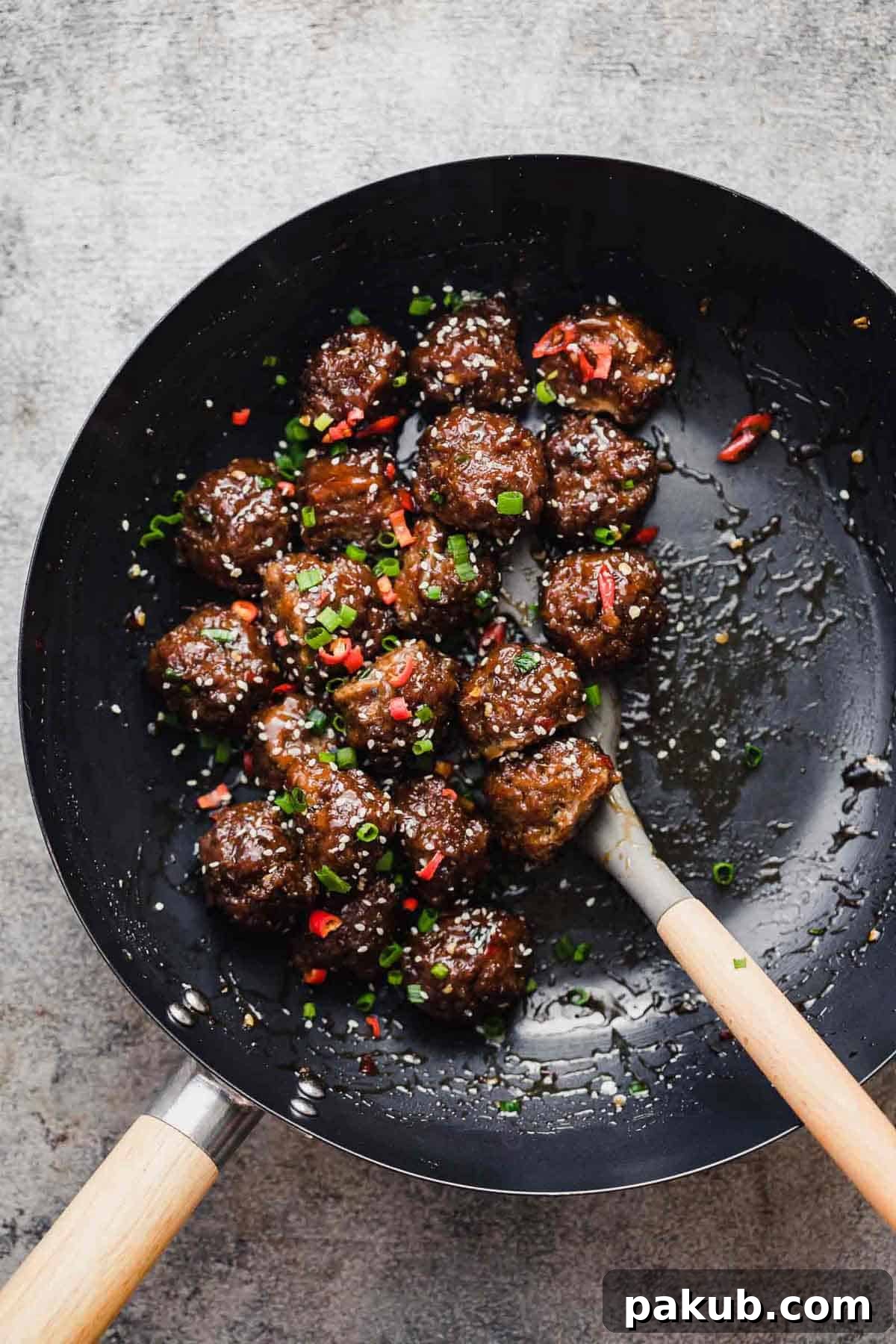 Irresistible Sticky Thai Meatballs A Fast Party Favorite 3 Sticky Thai Meatballs being tossed in a wok, covered in sauce