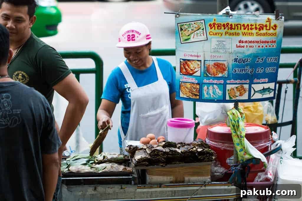 A focused individual expertly preparing a delicious street food meal, showcasing the vibrant culinary skills often found in Bangkok's bustling markets