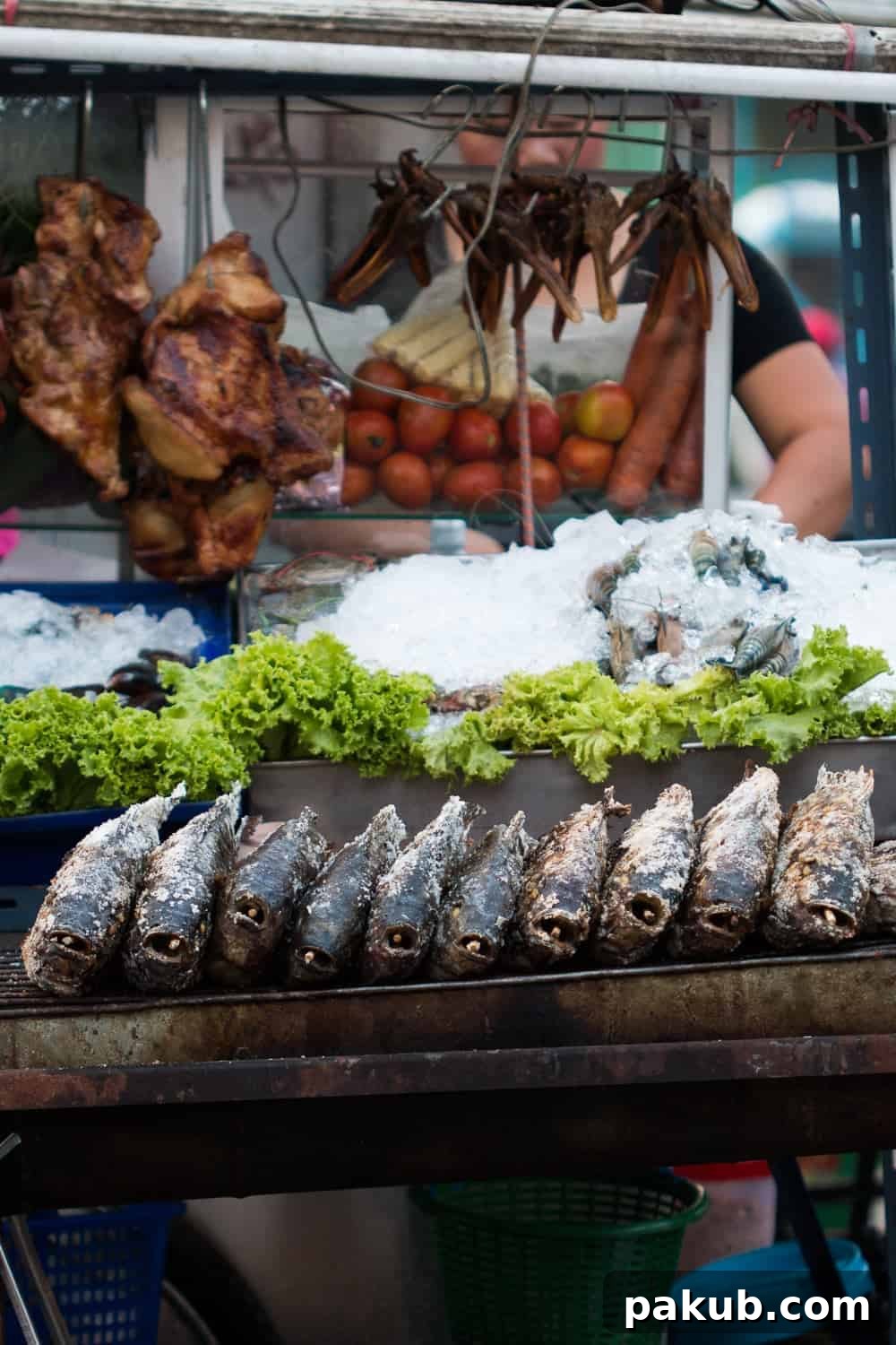 An enticing display of fresh fish, seasoned chicken, crisp green vegetables, and ripe tomatoes arranged beautifully on a vibrant street food cart, showcasing Bangkok's diverse offerings