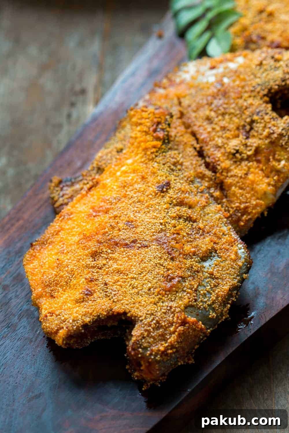 Crispy Mangalorean Fish Fry Close-up of crispy Rava Pomfret Fish Fry served on a wooden platter