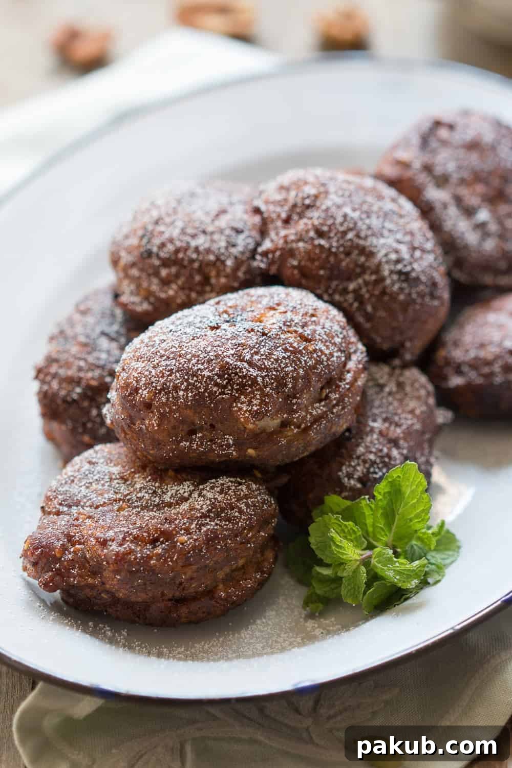 Another close-up of the Spiced Indian Banana Fritters on a white plate, highlighting their appetizing texture and golden color.