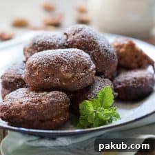The fritters served in a white plate and garnished with mint leaves.