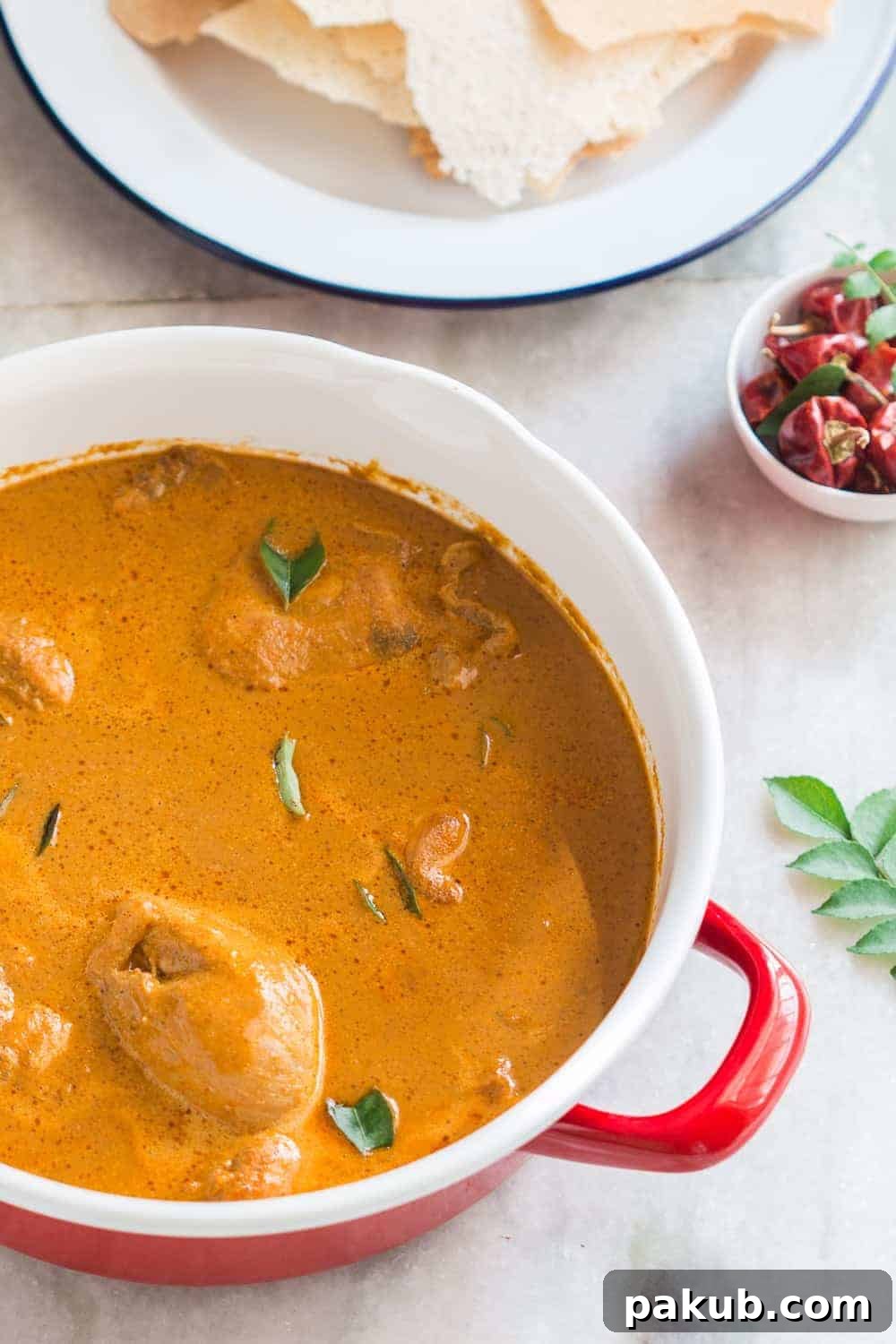 Kori Rotti simmering in a pot Mangalorean chicken curry simmering in a traditional red cooking pot.