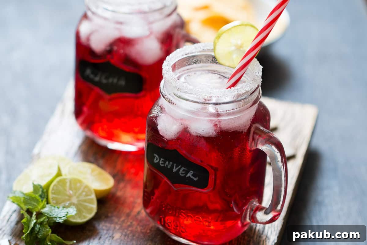 Cranberry Ginger Holiday Cocktail served in mason jars with sugar coated rims and a slice of lime.