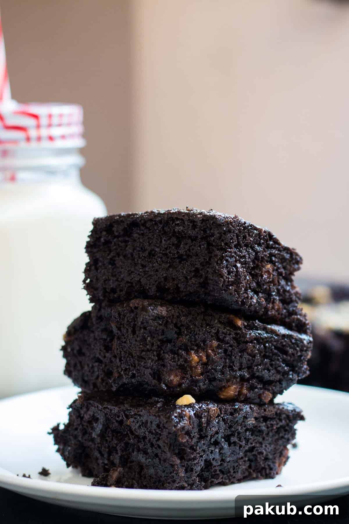 Rich, fudgy eggless chocolate brownies served on a pristine white plate, promising a decadent experience.