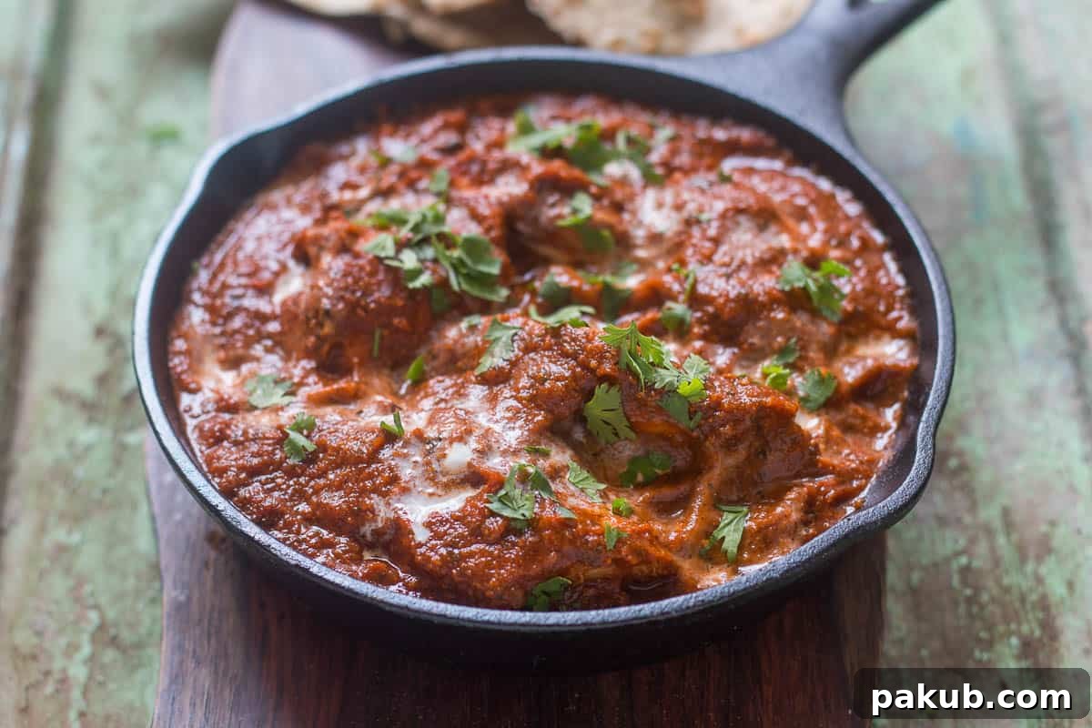 Guilt-Free Chicken Tikka Masala 2 The healthier version of Chicken Tikka Masala garnished with fresh coriander in a pan, showcasing its rich, deep orange color.