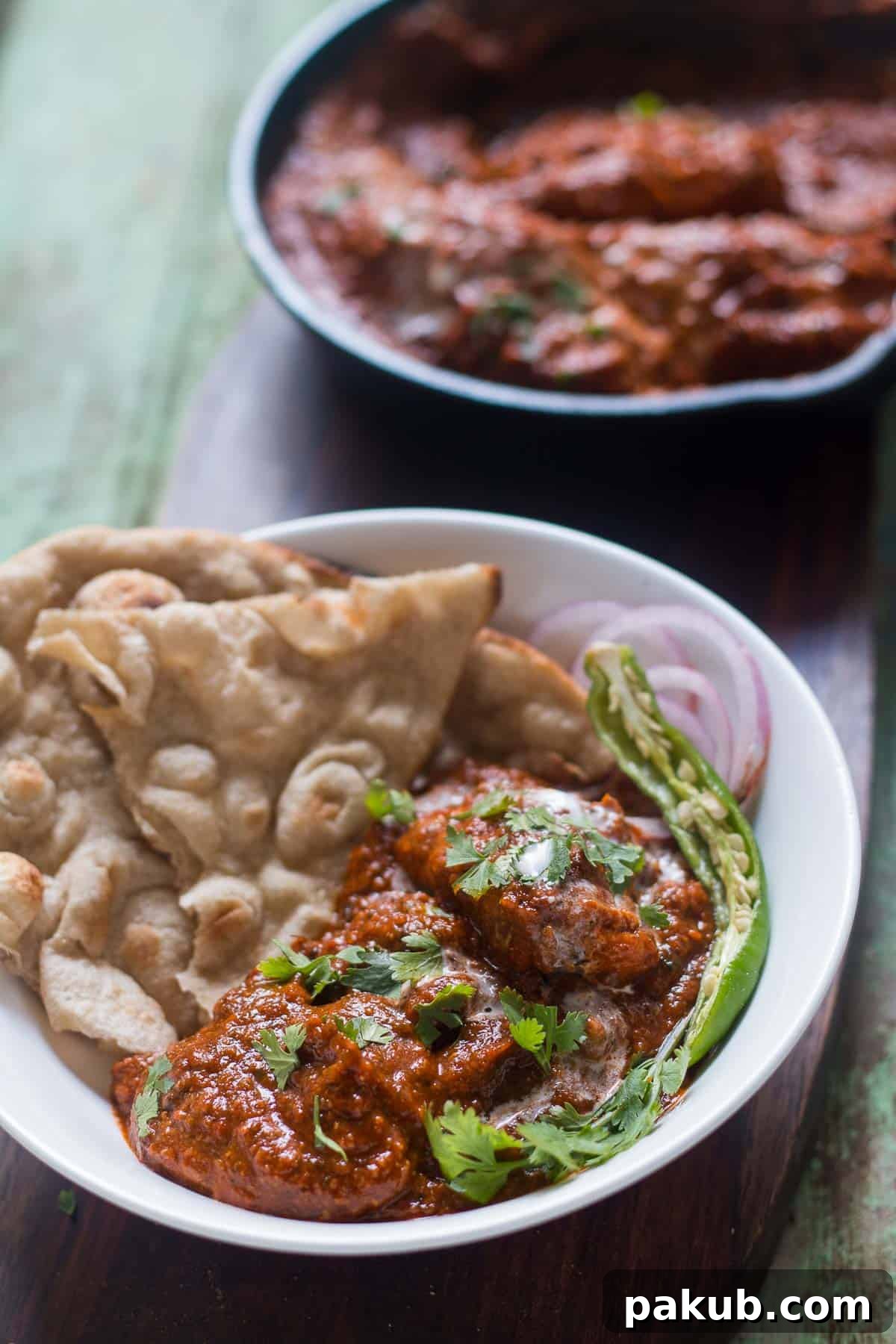 Guilt-Free Chicken Tikka Masala 6 The Zero Oil Chicken Tikka Masala beautifully plated alongside soft tandoori rotis, crisp onion rings, and a fiery green chili, ready to be enjoyed.