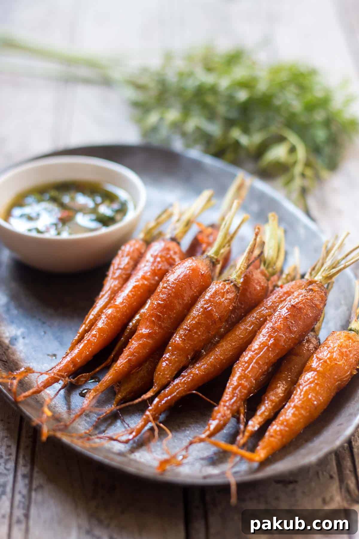 Perfectly plated Honey Ginger Roasted Carrots, generously drizzled with fresh Carrot Greens Chimichurri.
