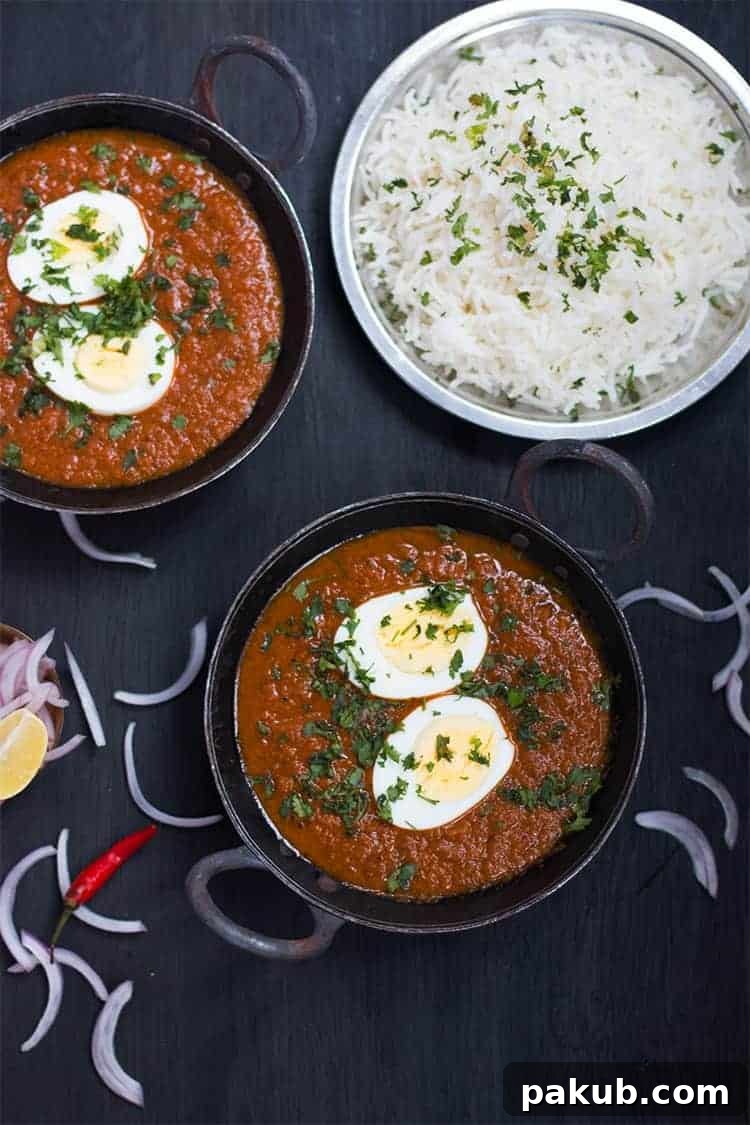 Indian Egg Curry served with a side of fluffy white rice in a black kadhai, ready for a meal