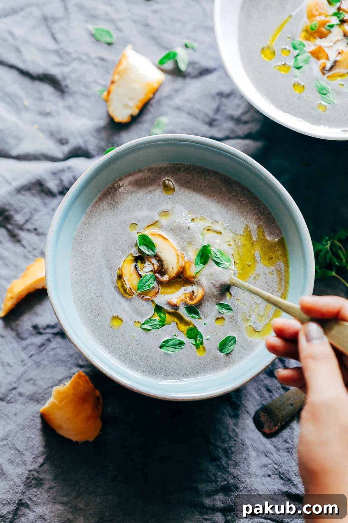 A close-up of a serving of healthy creamy mushroom soup in a rustic bowl.
