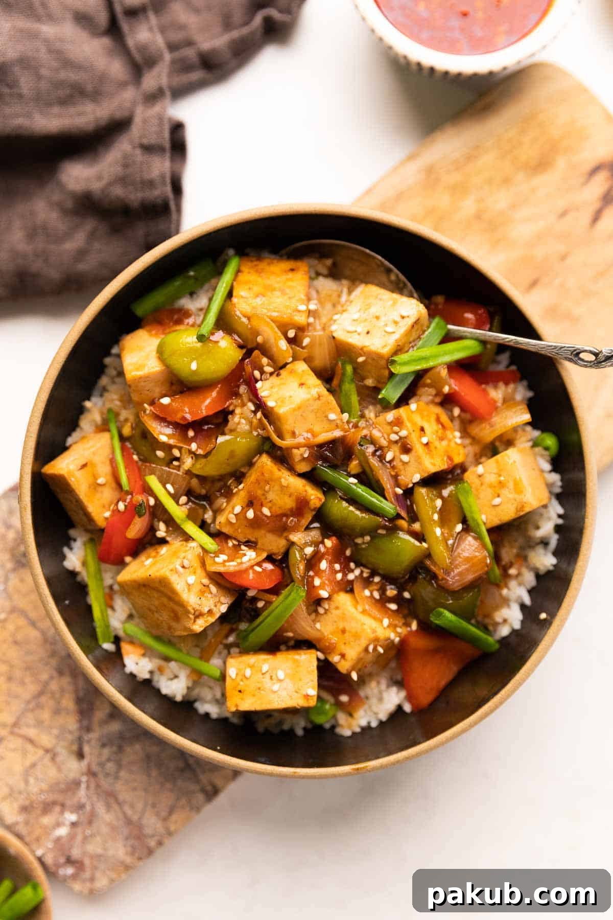 Zesty Sweet Tofu Sizzle 2 Sweet Chili Tofu Stir Fry served over rice, garnished with fresh herbs