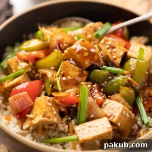 Sweet Chili Tofu Stir Fry served over rice in a bowl.