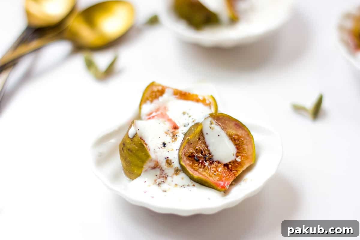A close-up shot of roasted figs with cardamom yogurt served in a tiny white bowl, garnished with honey and ground cardamom, showcasing its beautiful presentation.