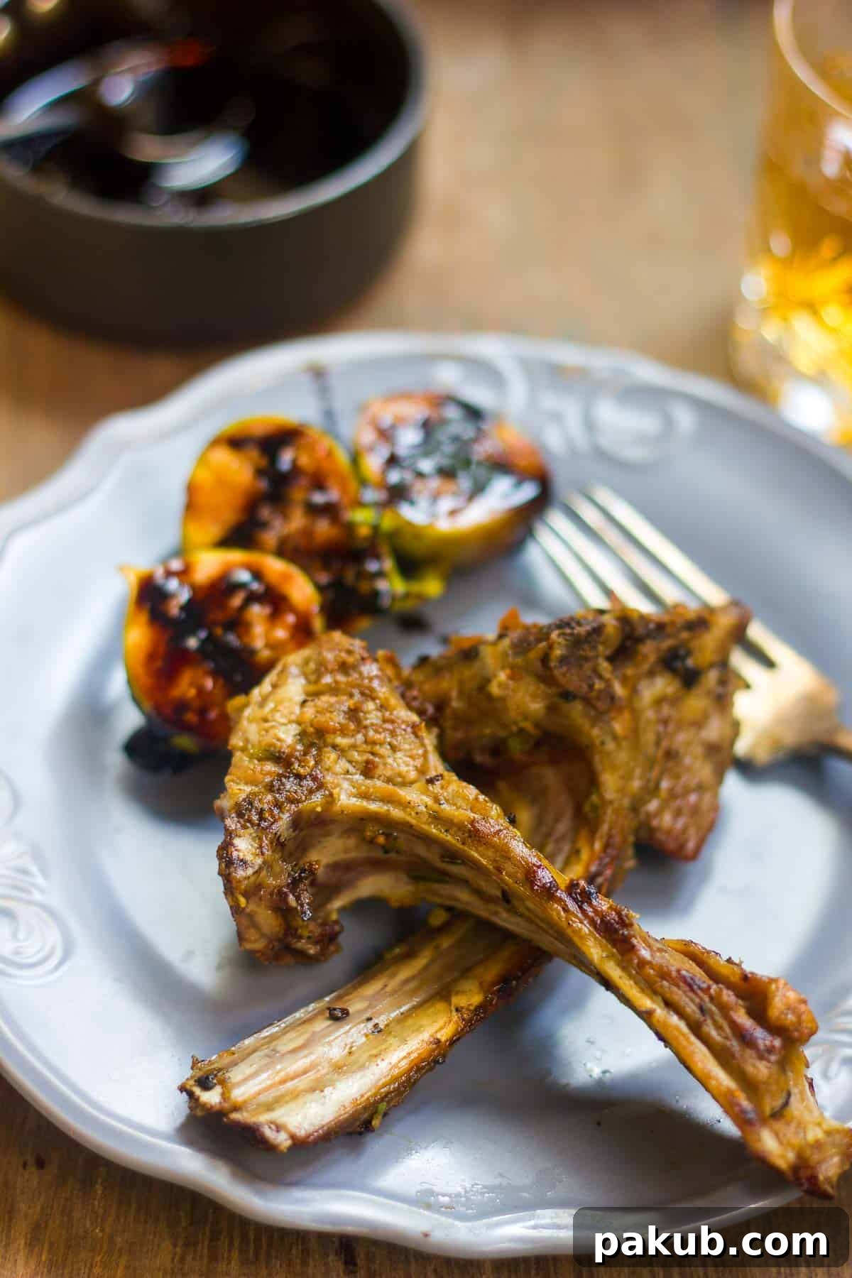 Aromatic Lamb with Fig Balsamic Glaze 5 Elegantly plated spiced lamb chops with roasted figs and balsamic reduction on a blue ceramic plate.