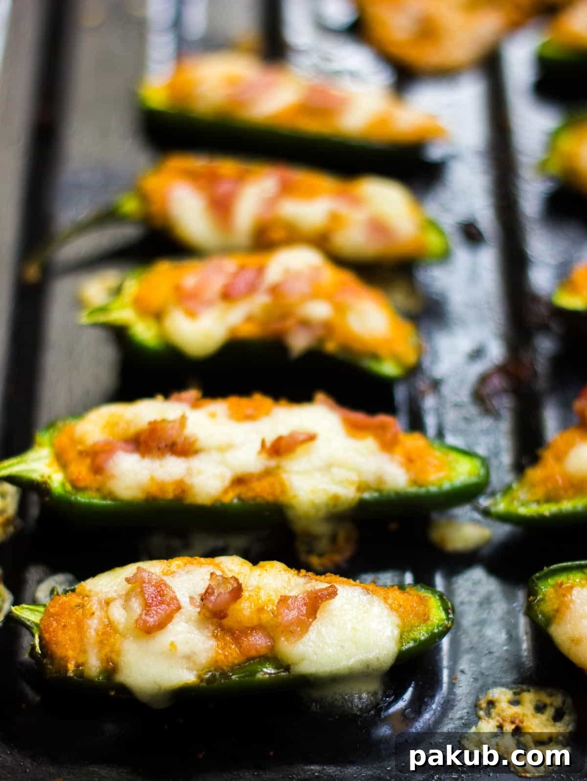 Oven Baked Cottage Jalapeno Delights 4 Close-up view of freshly baked jalapeno poppers with melted cheese bubbling and golden breadcrumbs, presented on a rustic board.