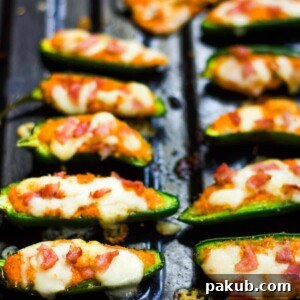 Beautifully golden-brown baked jalapeno poppers, fresh from the oven, served on a platter, ready to be enjoyed.