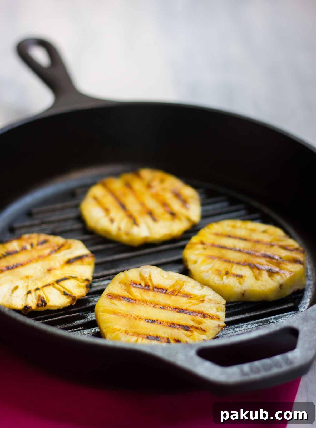 Grilled Pineapple Habanero Salsa 2 Fresh pineapple slices being grilled on a hot pan for Spicy Grilled Pineapple Salsa, showing beautiful char marks.