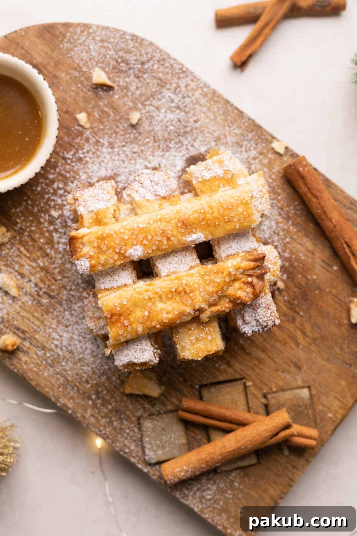 Apple Pie Chips Ready to Serve A stunning close-up shot of golden-brown Apple Pie Chips, artistically stacked on a wooden board, with a rich salted caramel sauce in the background.