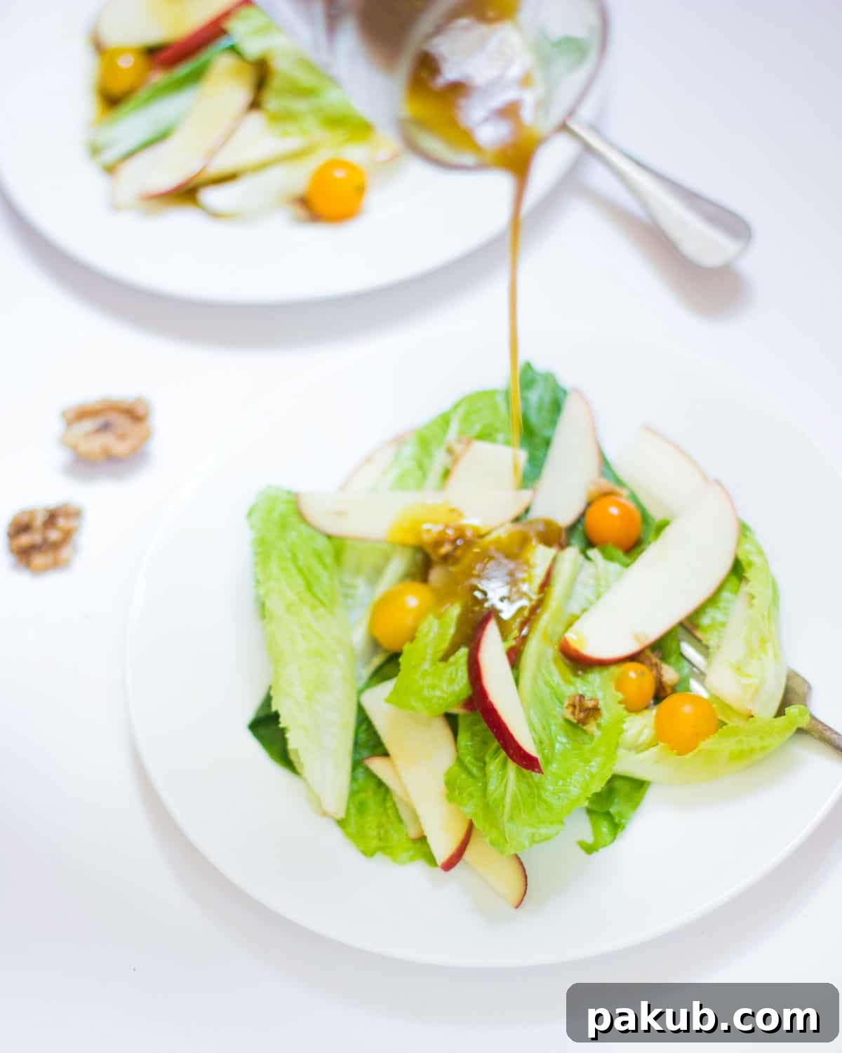 Refreshing Summer Apple Walnut Delight 3 A stream of golden honey mustard dressing being drizzled generously over a fresh Apple Walnut Summer Salad in a pristine white bowl, highlighting the salad's freshness.